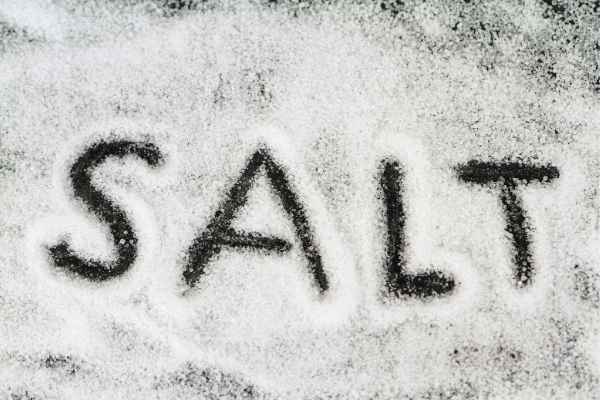 the word salt written in salt by tracing the letters in the crystals on a black background